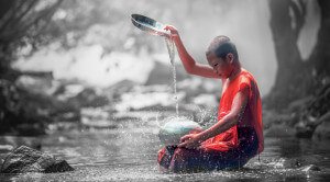Motiv Junge spielt mit Wasser